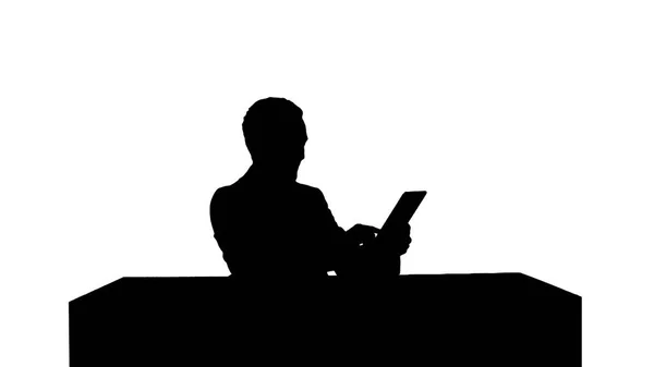 Silhouette Business man som arbetar på digital tablet på hans bord i hans kontor — Stockfoto