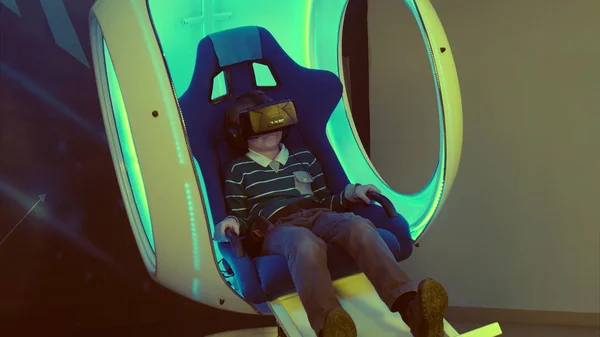 Niño disfrutando de la realidad virtual en una silla interactiva en movimiento —  Fotos de Stock