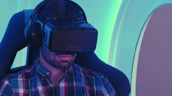 Young man sitting in interactive virtual reality chair