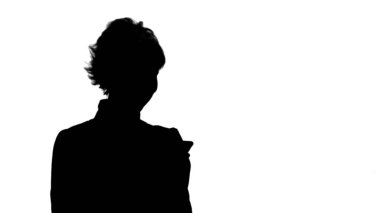 Silhouette genç çekici kadın akıllı telefonda çalışır ve gülümseme parça mat