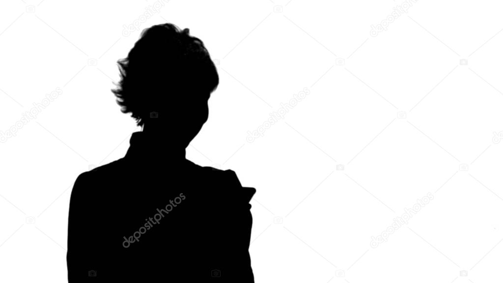 Silhouette Young attractive woman works on smartphone and smiles track matte