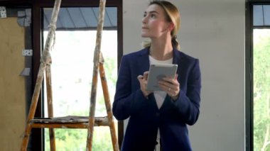 Elinde dijital tablet ile inşa ediliyor yeni bir ambar iç inşaat gözetmen denetler