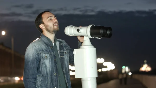 Ο άνθρωπος που χρησιμοποιεί ένα τηλεσκόπιο που λειτουργεί με κέρμα απολαμβάνοντας μια υπέροχη θέα της πόλης — Φωτογραφία Αρχείου