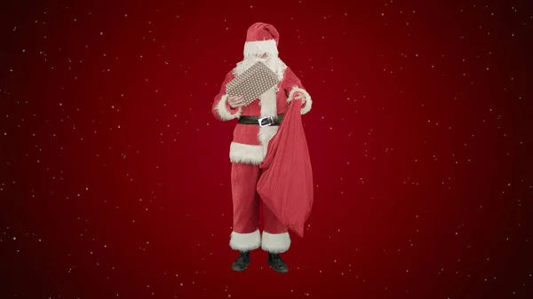 Weihnachtsmann mit seinem Sack voller Geschenke auf rotem Grund mit Schnee — Stockfoto