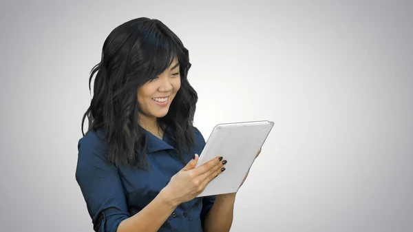 Mujer joven sonriente trabajando en tableta sobre fondo blanco — Foto de Stock
