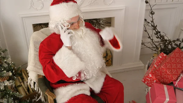 Santa Claus mluví po telefonu, který si přeje Veselé Vánoce — Stock fotografie