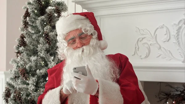 Mutlu Noel telefonunuzda Xmas ileti okuma ve onun koltuğa otururken gülümseyen baba — Stok fotoğraf