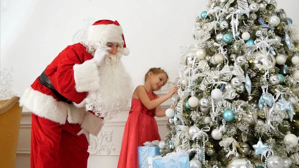 Santa Claus βοηθώντας αρκετά μικρό κορίτσι για να διακοσμήσετε το χριστουγεννιάτικο δέντρο — Φωτογραφία Αρχείου