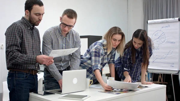 Dos arquitectos discutiendo diseño mientras compañeras de trabajo mirando la paleta de colores — Foto de Stock