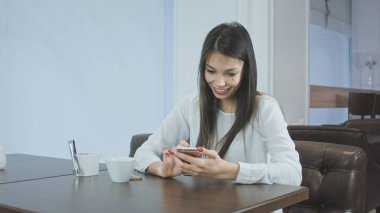 Bir kafede telefonunu kontrol gülümseyen güzel kadın