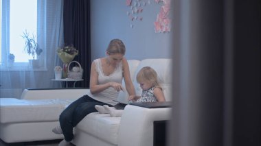 Genç anne şirin çocuk tablet kullanmayı öğrenme