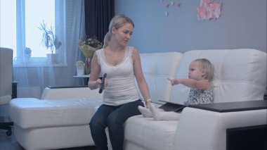 Kızı onu tv izlemek için sunarak dikkatini dağıtmak için anne tyring