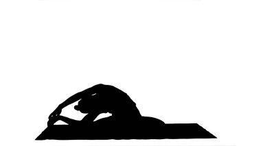 Genç kadın yoga pratik parça mat yaparken bacaklarını germe