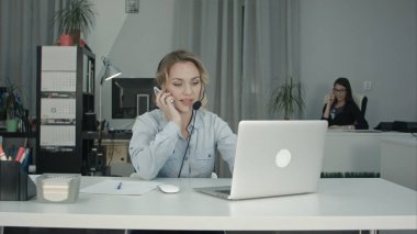 Çalışma iki gülümseyen kadın Merkezi yanıtlayan telefon ara. Bmcc Raw profesyonel vuruşta yüksek dinamik aralık ile. Örneğin kullanmadan reklam videosu, iş, tanıtım, yayın