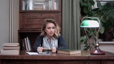 Genç kadın desperatley kitaplara bakıyorum ve öfkeyle bir kalem atma vurguladı