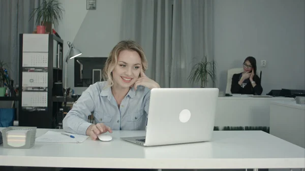 Jovem trabalhadora fazendo chamada de vídeo via laptop no escritório — Fotografia de Stock