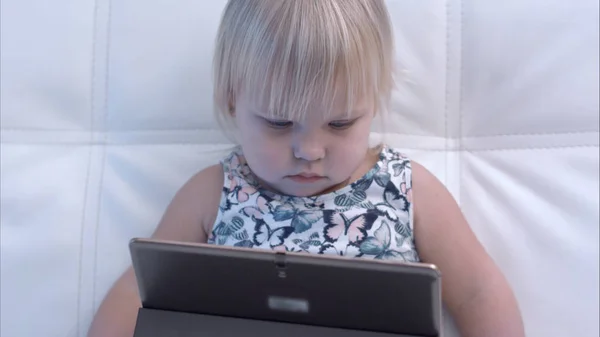Poważne dziewczynka ogląda tabletu — Zdjęcie stockowe