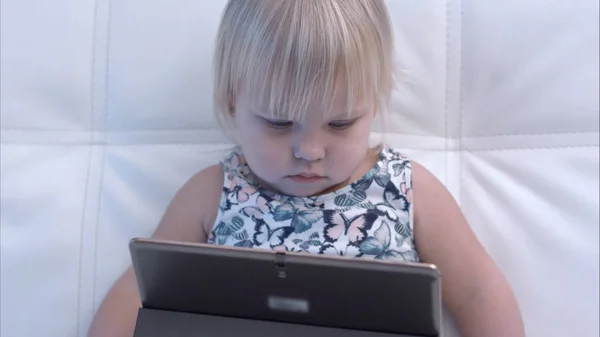 Niña seria mirando tableta — Foto de Stock