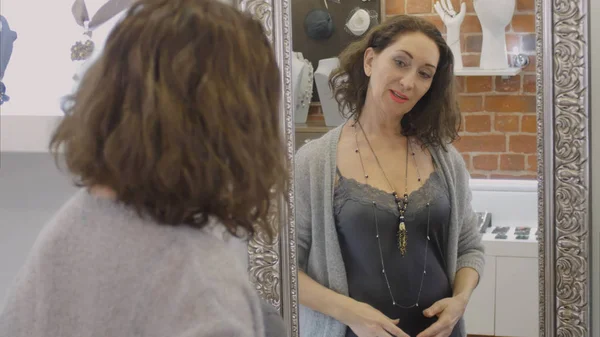 Elegante collar de mujer en el cuello delante del espejo en la tienda — Foto de Stock