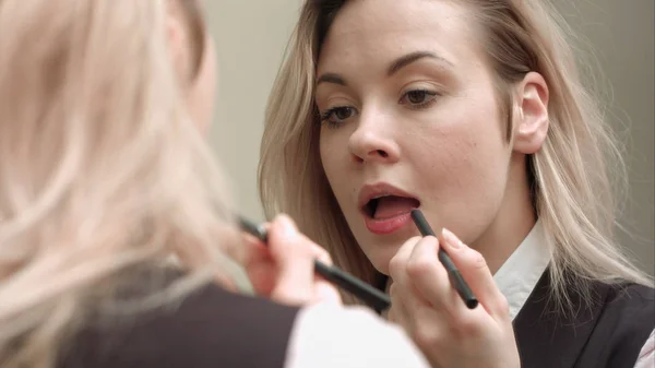 Young beautiful woman applying red lipstick on her lips — Stock Photo, Image