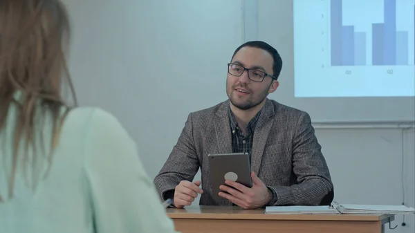 Professora profissional do sexo masculino explicando as principais ideias do ensaio fazendo discussão entre os alunos fazendo perguntas e compartilhando conselhos durante a aula de treinamento em sala de aula — Fotografia de Stock