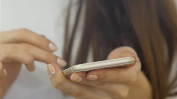 Manos de mujer joven utiliza un teléfono inteligente — Foto de Stock