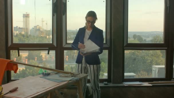 Vrouwelijke Architect met blauwdruk op bouwplaats — Stockvideo