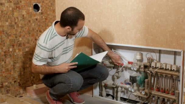 Muž si čte spotřeba vody instalace — Stock video
