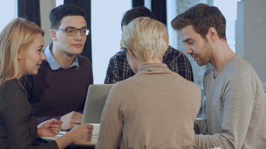 Modern bir stüdyoda beyin fırtınası yapan yaratıcı insanlar.