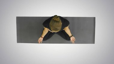 Çalışma dışarı, yoga yaparken çekici genç kadın egzersiz, yarım Lotus otururken, Namaste, meditasyon, kamera bir gülümseme ile beyaz arka plan üzerinde seyir içinde Ardha Padmasana ile palmiyeler