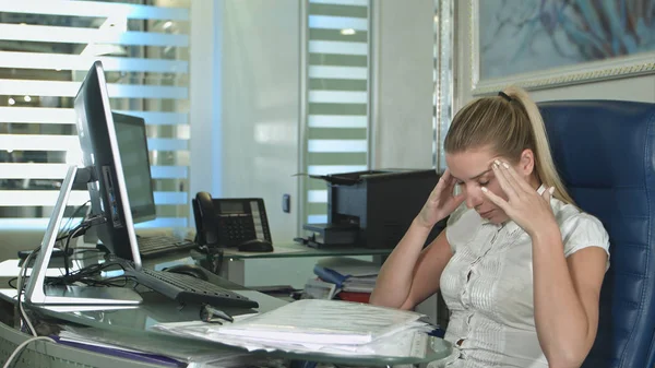 Giovane donna d'affari stanca e assonnata alla scrivania con un computer portatile — Foto Stock