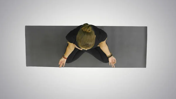 Attraente giovane donna che lavora fuori, facendo esercizio di yoga, Seduto a metà loto, Ardha Padmasana con palme in Namaste, meditando, guardando la fotocamera con un sorriso su sfondo bianco — Foto Stock