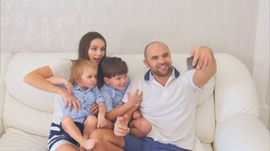 Gülümseyen aile komik selfies kanepede oturan alarak