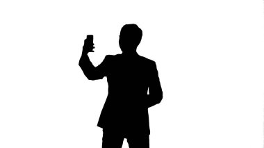 Siluet genç adam onun smartphone ile selfie fotoğraf çekme