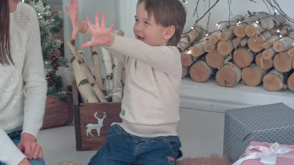 Young mother and excited boy counting Christmas presents on his fingers