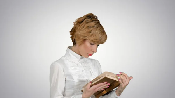 Joven empresaria concentrada sosteniendo y leyendo libro sobre fondo blanco — Foto de Stock