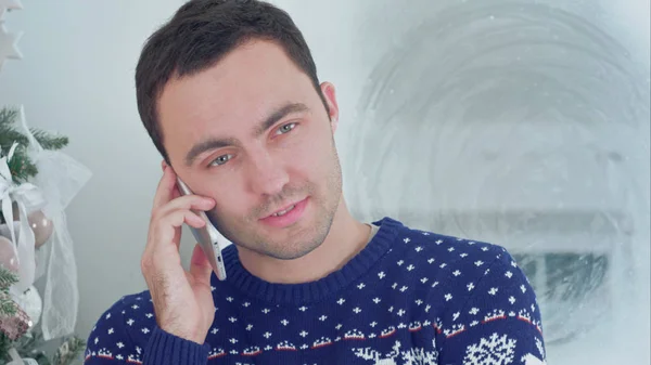 Hombre joven en jersey de Navidad hablando por teléfono — Foto de Stock