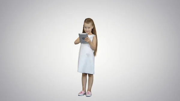 Menina pequena com computador tablet em fundo branco — Fotografia de Stock