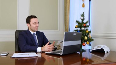 Genç işadamı ofiste kendi bilgisayarında görüntülü görüşme var