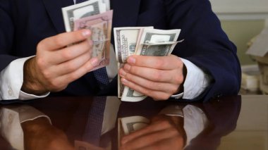 Bir masada sayım yüz dolar faturaları bir businessmans eller