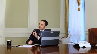 Biri iş adamı iş rahatsız ediyor ama o iş dizüstü bilgisayar ile devam ediyor