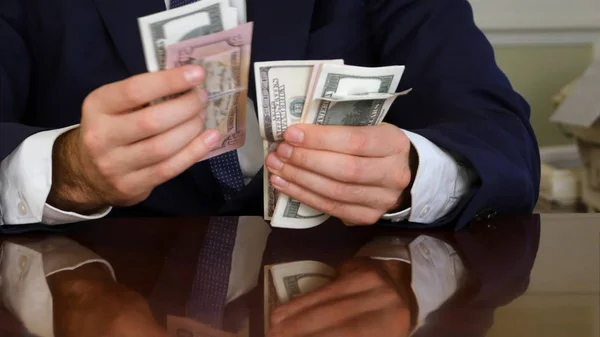 Бизнесмены руки подсчитывают стодолларовые купюры за столом Стоковое Фото