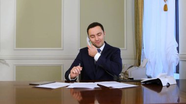 Modern ofis iş telefonu görüşmeye göre analiz çalışan genç emin başarılı iş adamı