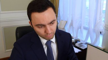 Dalgın memnun genç işadamı ofis okuma içinde dosyalar klasörler evrak işi