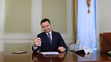 Selfie fotoğrafta cep telefonu ile ofiste mutlu işadamı