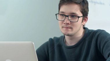 Üniversitesi video sohbet için dizüstü bilgisayar kullanarak genç çekici erkek öğrenci