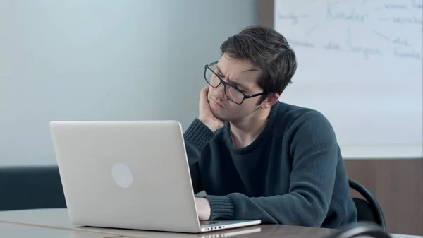 Nadenkend student met laptop studeren in de bibliotheek van de Universiteit — Stockfoto