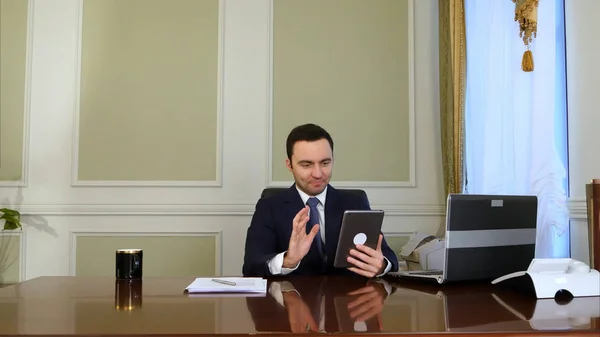 Empresario charlando en tableta y haciendo papeleo en la oficina — Foto de Stock