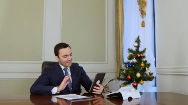 İşadamı Noel internet üzerinden iş ortaklarıyla tablet ile kutladı