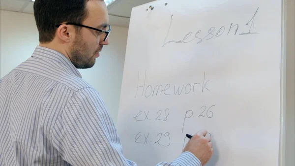 Ung Lärare Glasögon Skriver Hem Arbete Övningar Blädderblock Nära Håll — Stockfoto